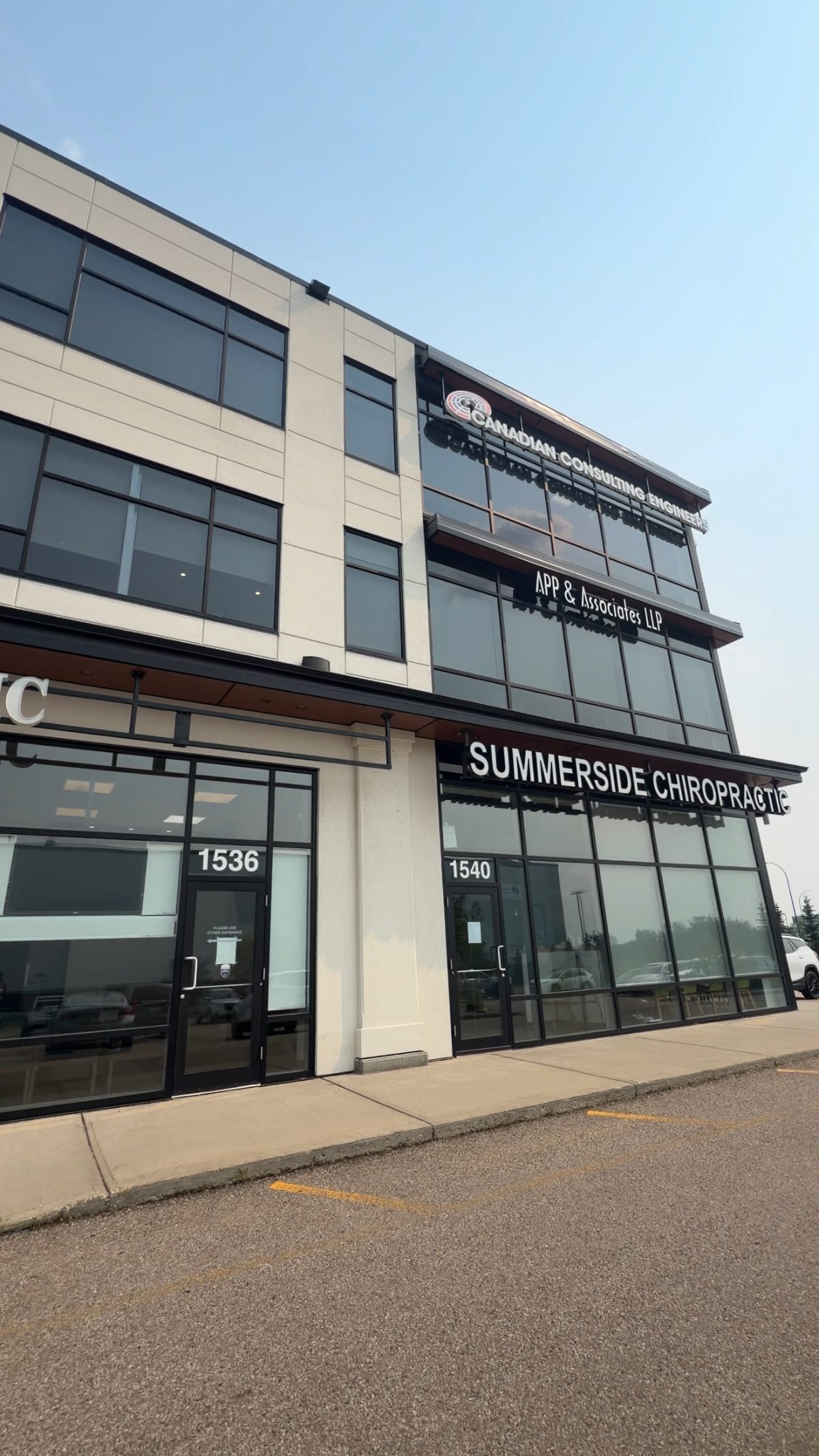 The building entrance in South Edmonton where Drop of Dew Counselling is located, a modern three-storey office with ground-floor glass doors